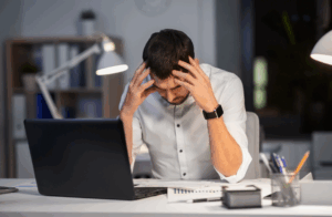 Selbstständiger Mann am Schreibtisch mit Frust über ausbleibende Kunden – Symbolbild für falsche Preisgestaltung im Coaching-Business